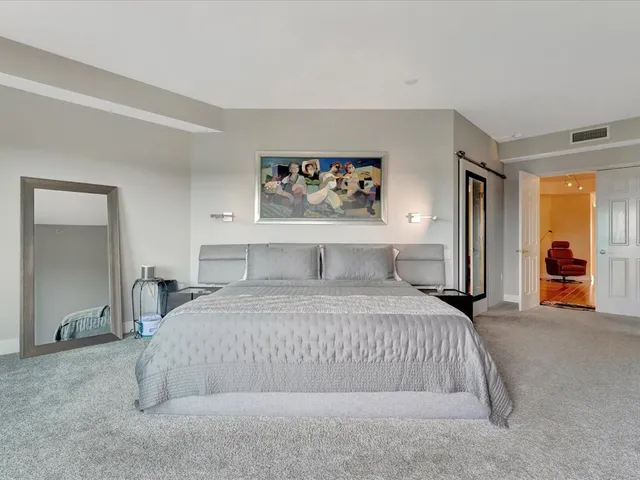 a bedroom with a large bed and a chandelier