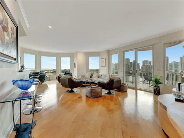 a living room with furniture a floor to ceiling window and potted plants