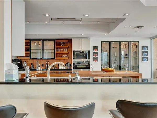 a kitchen with a white table chairs and a potted plant