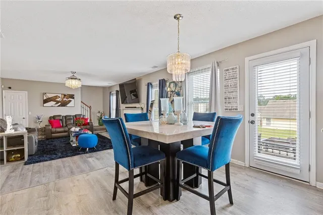 a view of a dining room and livingroom with furniture wooden floor a chandelier