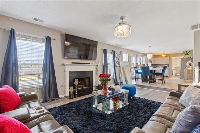 a living room with furniture a fireplace and a flat screen tv