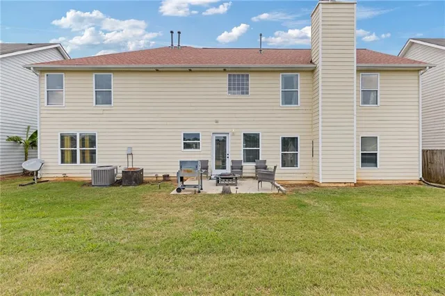 a view of a house with backyard and sitting area