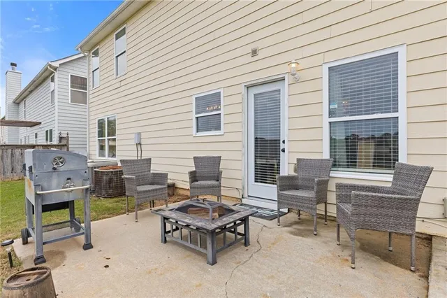 a backyard of a house with barbeque oven table and chairs