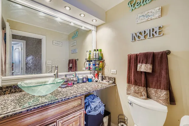 a bathroom with a granite countertop sink and a mirror