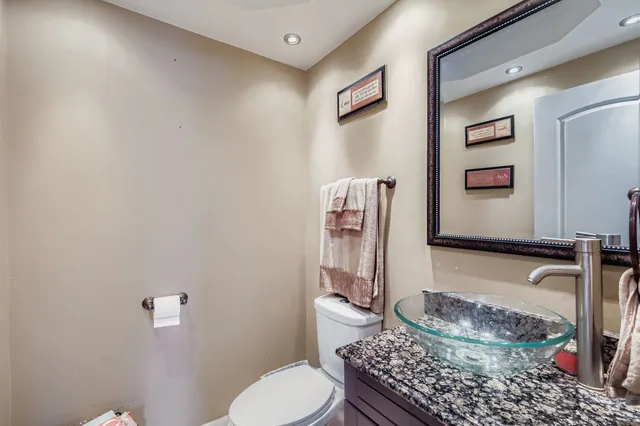a bathroom with a granite countertop toilet and a sink
