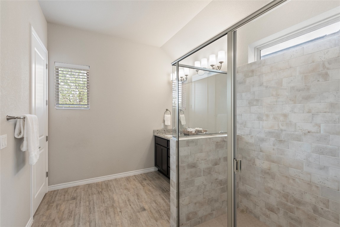 121 Bolivar Way, Unit 101 San Marcos, TX 78666 - Photo 13 of 33 a bathroom with a granite countertop shower and a sink