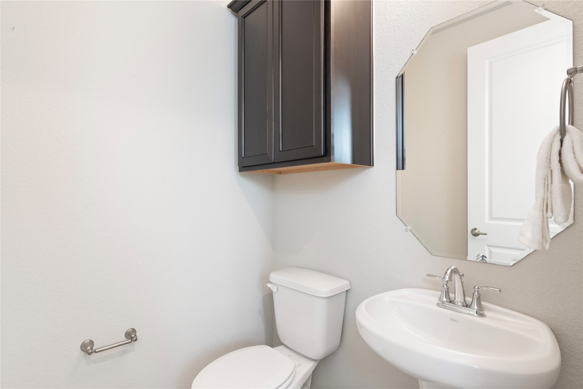 121 Bolivar Way, Unit 101 San Marcos, TX 78666 - Photo 19 of 33 a bathroom with a toilet a sink and mirror