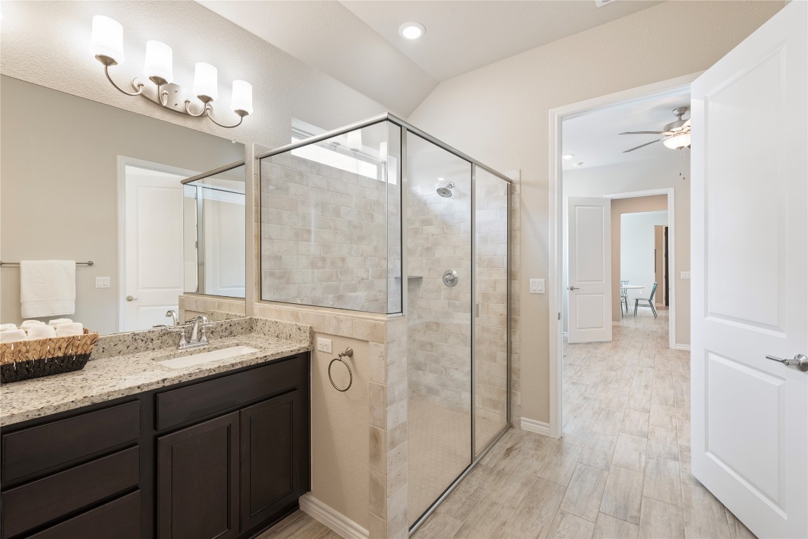 121 Bolivar Way, Unit 101 San Marcos, TX 78666 - Photo 6 of 33 a bathroom with a granite countertop shower sink and mirror