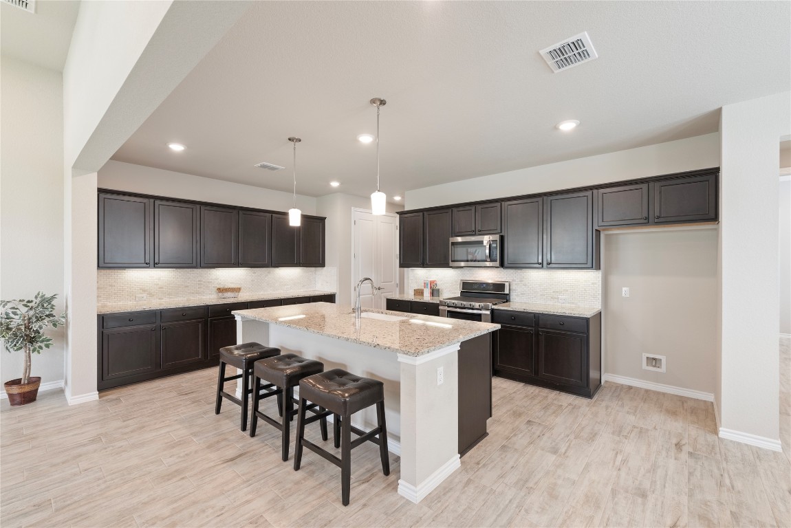 121 Bolivar Way, Unit 101 San Marcos, TX 78666 - Photo 8 of 33 a large kitchen with a table and chairs in it