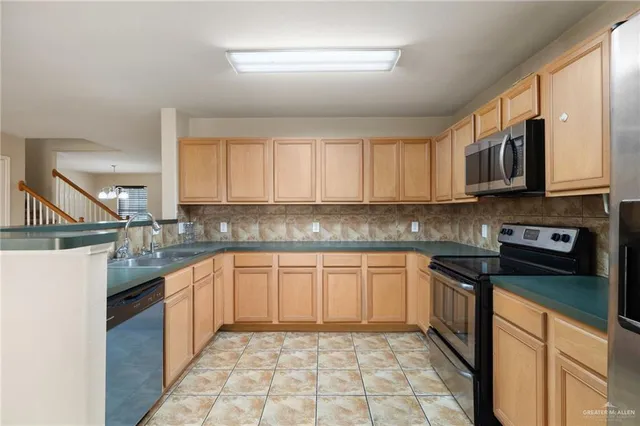 a kitchen with refrigerator a microwave a sink and cabinets