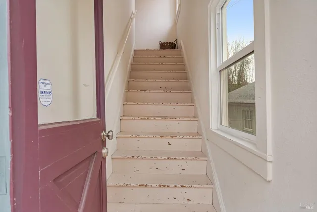 a view of staircase with white walls and windows