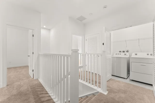 a view of a hallway with white cabinets