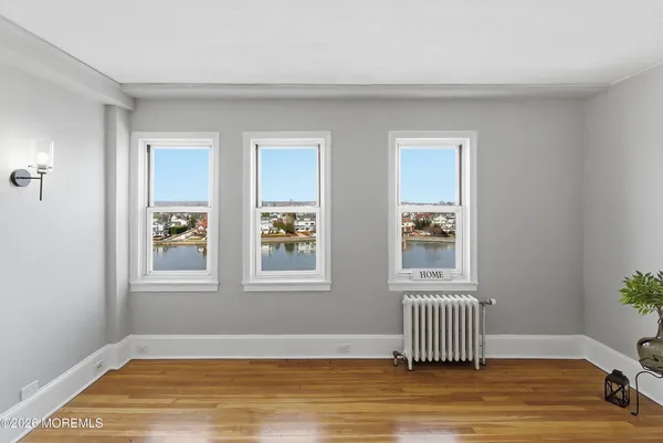 a view of empty room with wooden floor and window