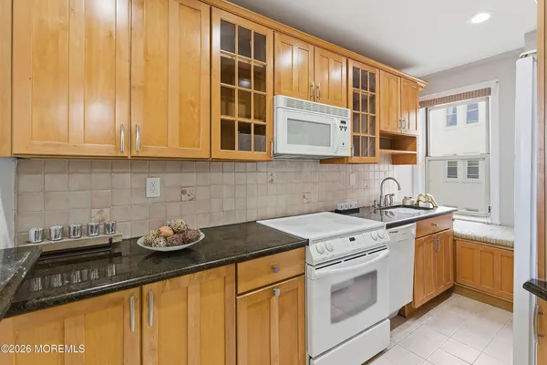 a kitchen with stainless steel appliances granite countertop white cabinets and a stove