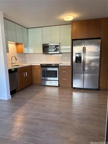 a large kitchen with stainless steel appliances granite countertop a stove a sink and a refrigerator