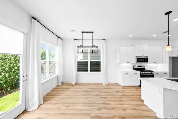 a view of a kitchen with wooden floor and stainless steel appliances