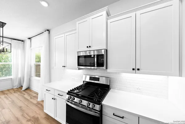 a kitchen with granite countertop a sink and a stove top oven