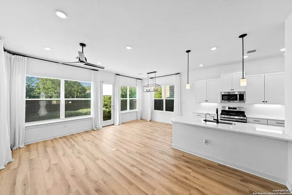a large kitchen with stainless steel appliances a large window a oven a counter space and a window