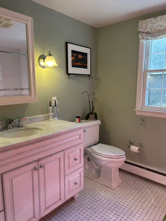 a bathroom with a granite countertop toilet a sink and a mirror