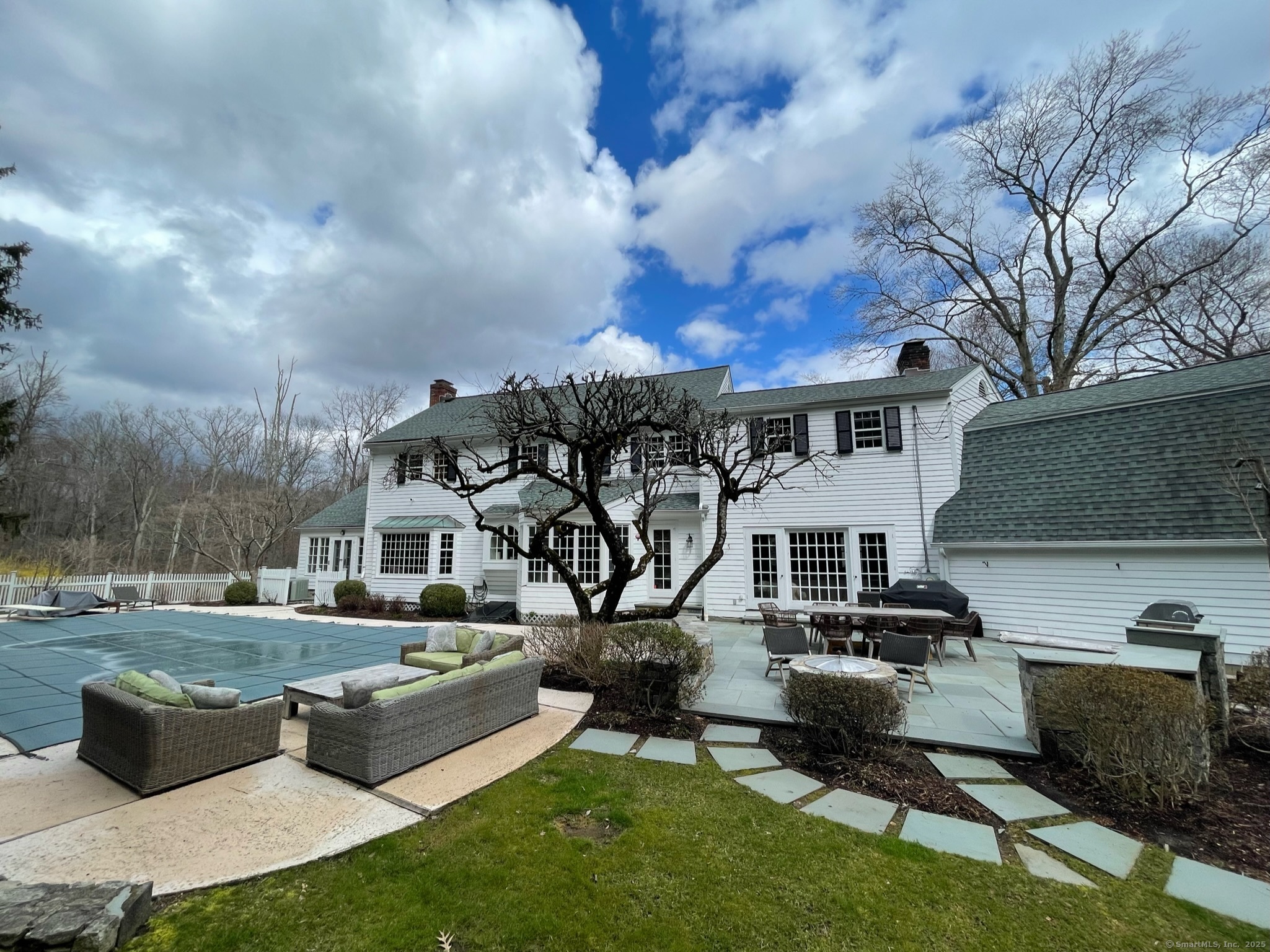 25 Deacons Lane Wilton, CT 06897 - Photo 12 of 37 a front view of a house with garden and sitting area