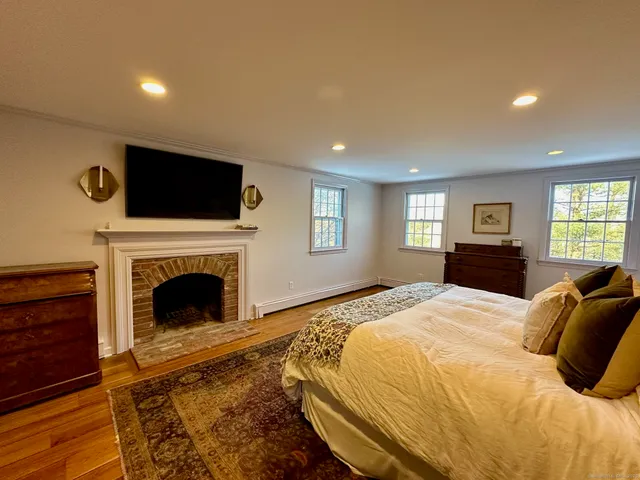 a spacious bedroom with a bed and a flat screen tv