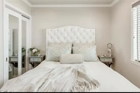 a bedroom with a bed and a large mirror