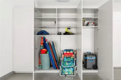 a utility room with lots of clutter and cabinets