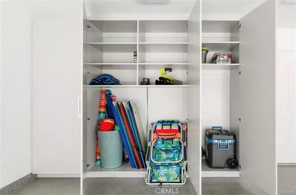a utility room with lots of clutter and cabinets