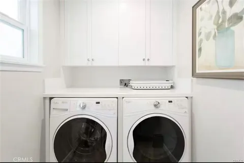 a view of washer and dryer with kitchen in the background