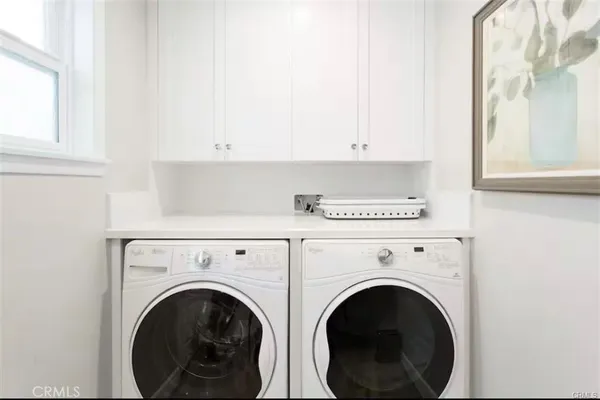 a view of washer and dryer with kitchen in the background