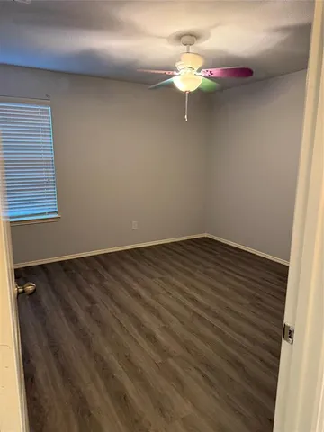 a view of a room with wooden floor and fan