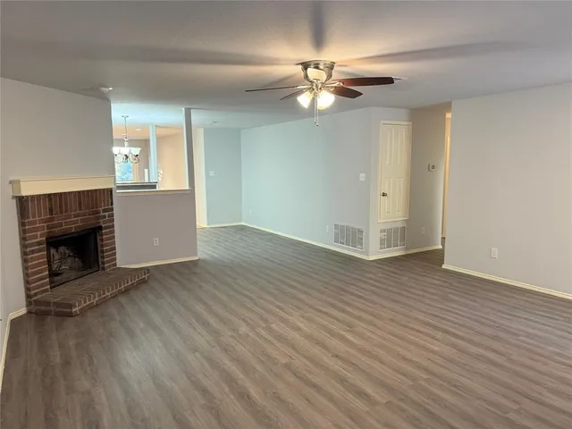 a view of a livingroom with wooden floor and a fireplace