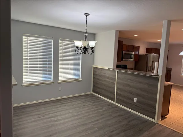 a view of a room with wooden floor and windows