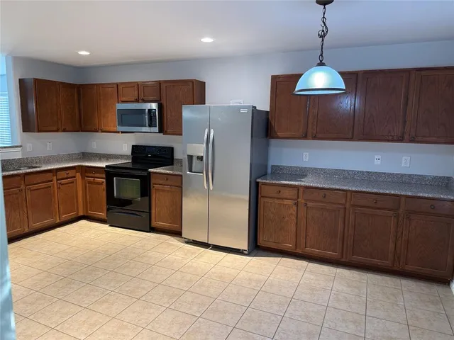 a kitchen with stainless steel appliances granite countertop a sink a stove a refrigerator and cabinets
