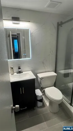 a bathroom with a sink mirror vanity and toilet