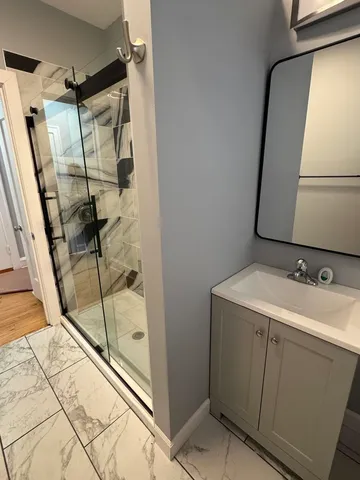 a bathroom with a sink and mirror with bathtub