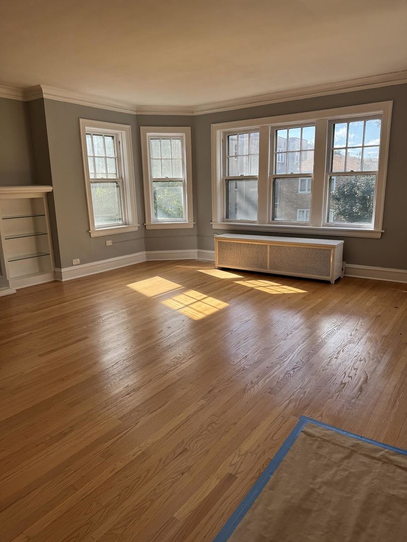 6231 North Francisco Avenue, Unit 2S Chicago, IL 60659 - Photo 2 of 24 a view of an empty room with wooden floor and a window