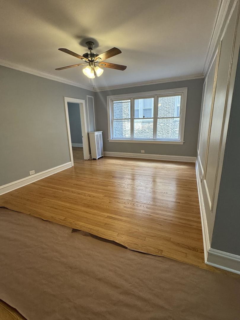 6231 North Francisco Avenue, Unit 2S Chicago, IL 60659 - Photo 6 of 24 a view of an empty room with wooden floor and a window