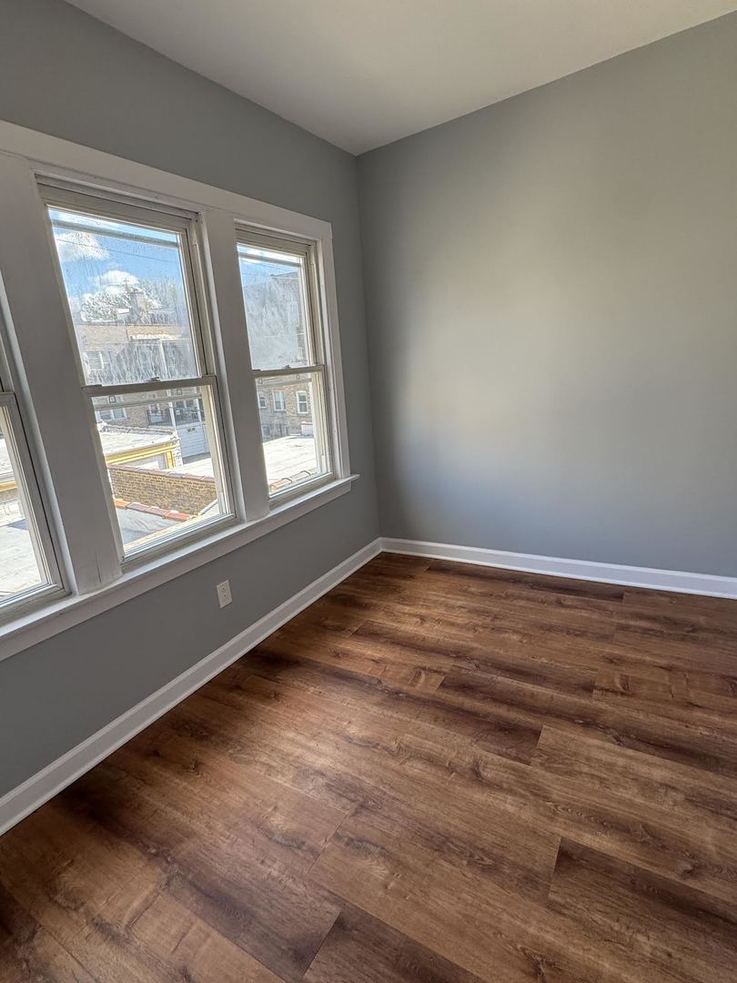 6231 North Francisco Avenue, Unit 2S Chicago, IL 60659 - Photo 8 of 24 a view of empty room with wooden floor and fan