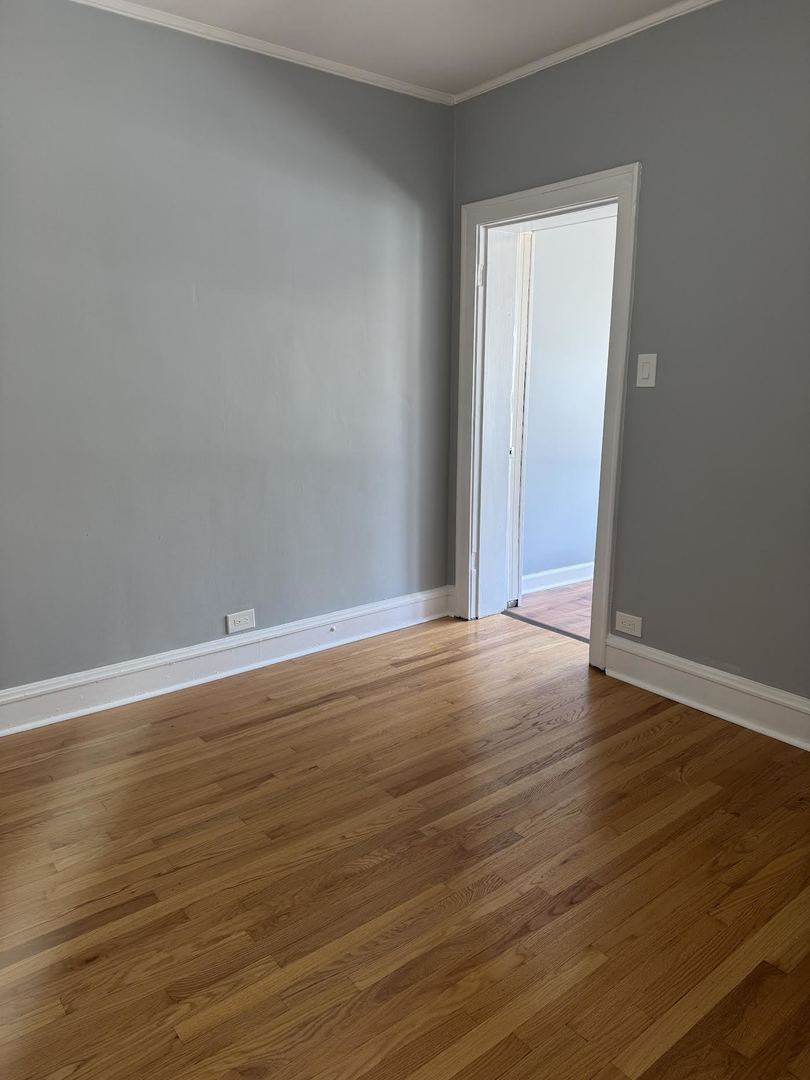 6231 North Francisco Avenue, Unit 2S Chicago, IL 60659 - Photo 10 of 24 a view of an empty room with wooden floor