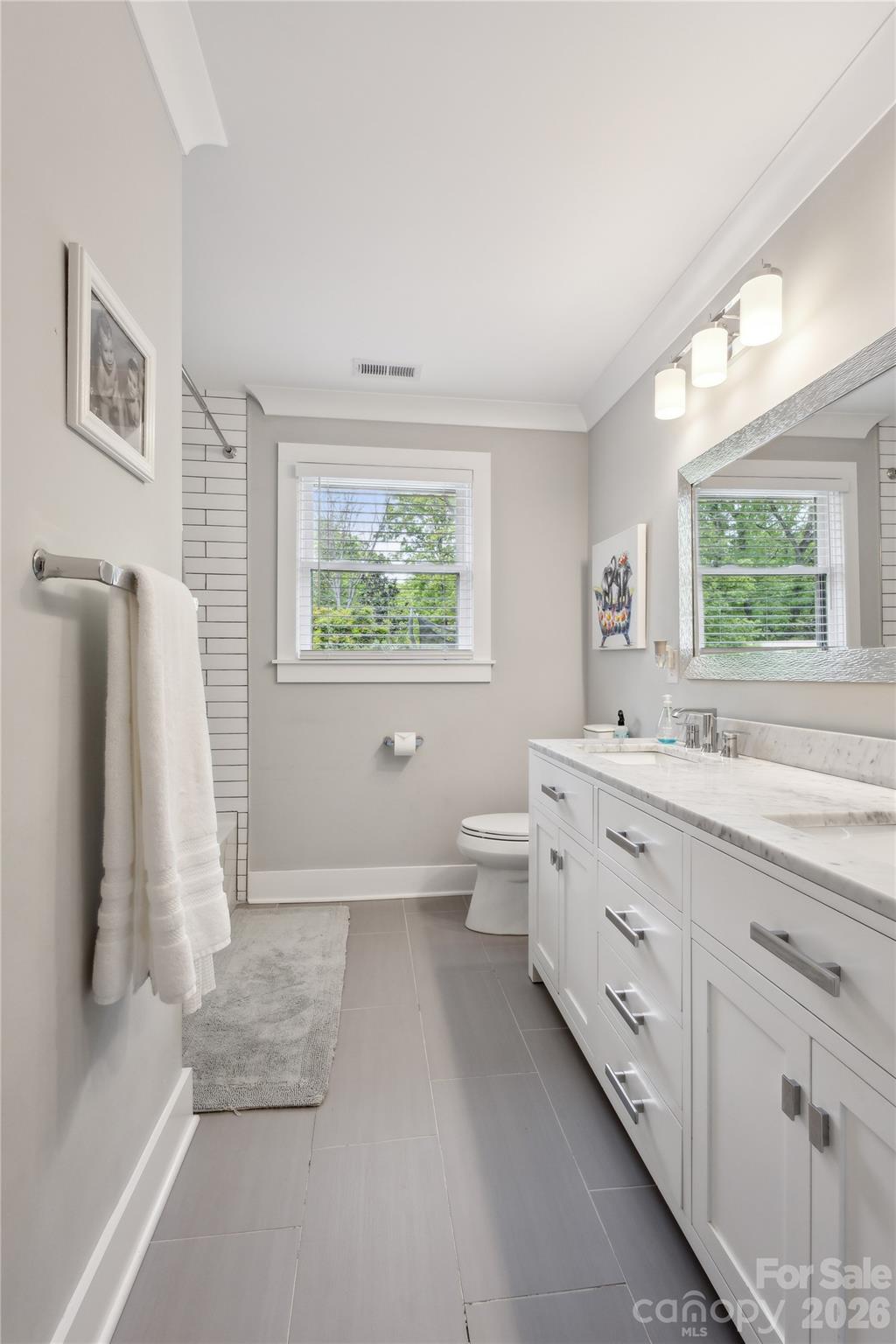 7200 Monroe Road Charlotte, NC 28212 - Photo 22 of 37 a bathroom with double vanity sink a toilet a window and vanity