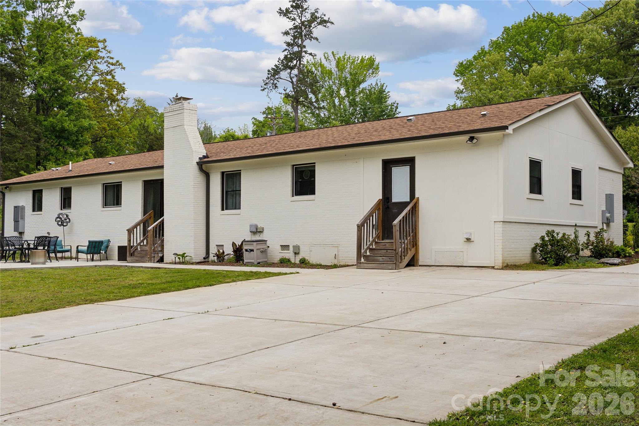 7200 Monroe Road Charlotte, NC 28212 - Photo 32 of 37 a view of a white house with a yard and plants