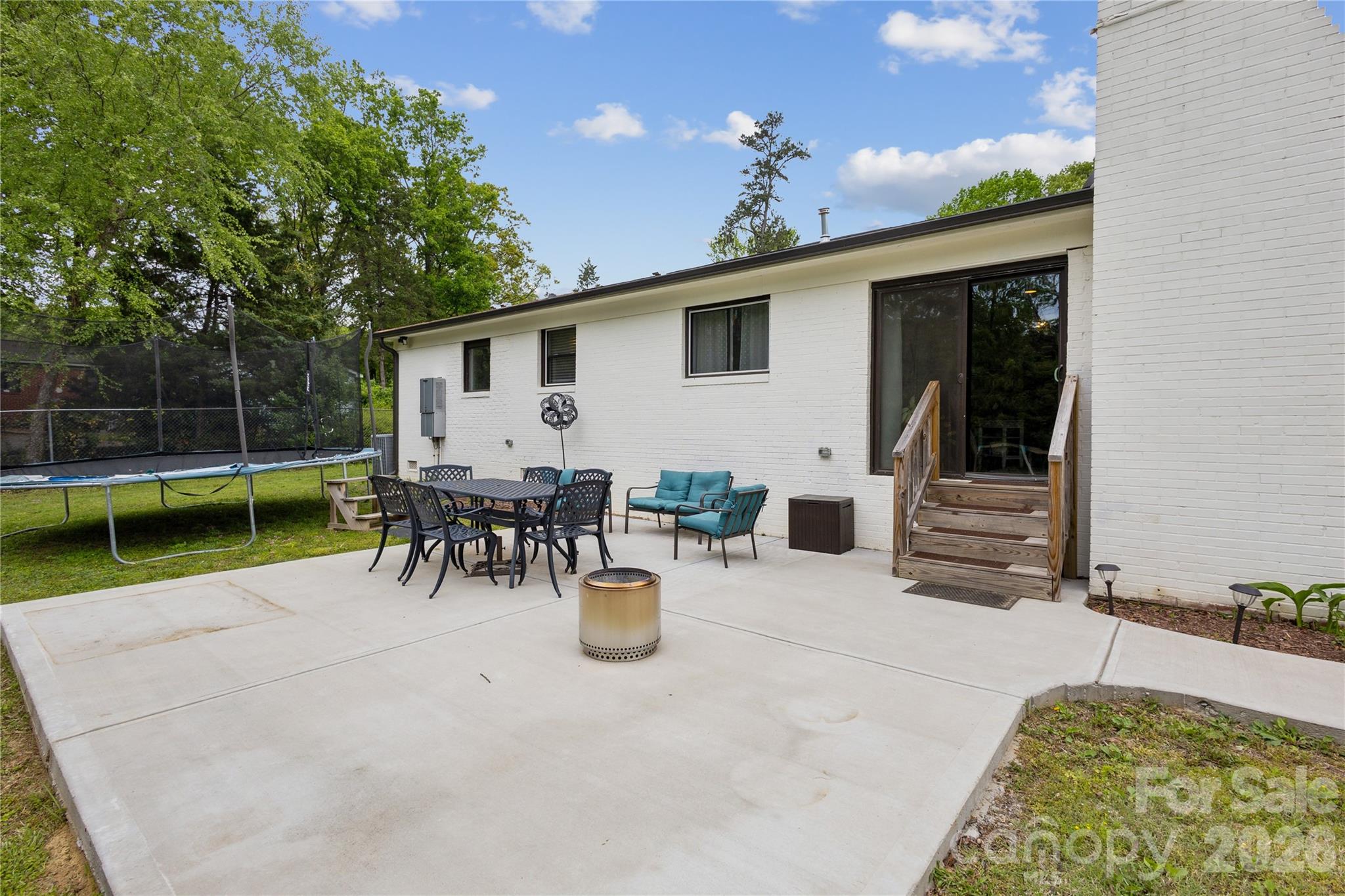 7200 Monroe Road Charlotte, NC 28212 - Photo 33 of 37 a view of a patio with dining table and chairs with wooden fence