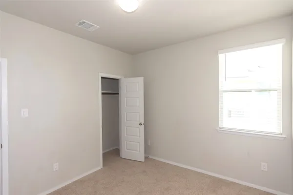 an empty room with windows and closet