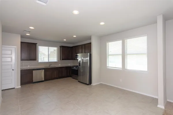 a large kitchen with a large window and a refrigerator