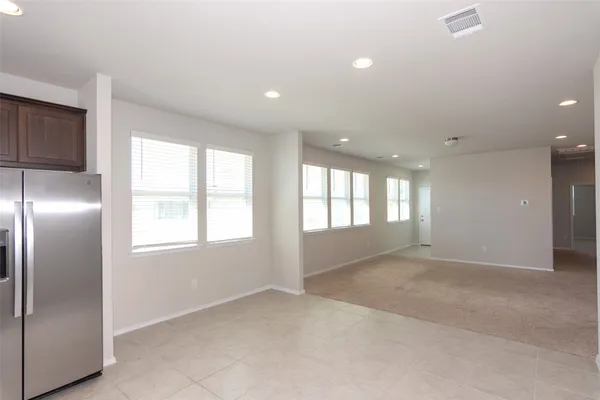 a view of an empty room with windows and closet