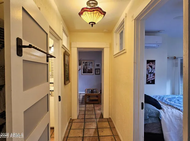 a view of a hallway with a dining table & a chandelier