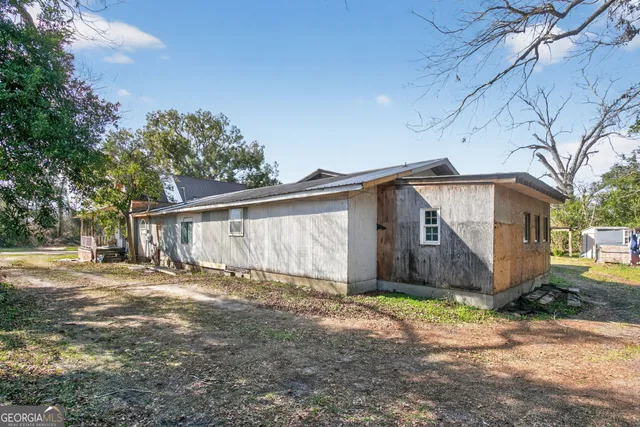 a view of a small house with a yard