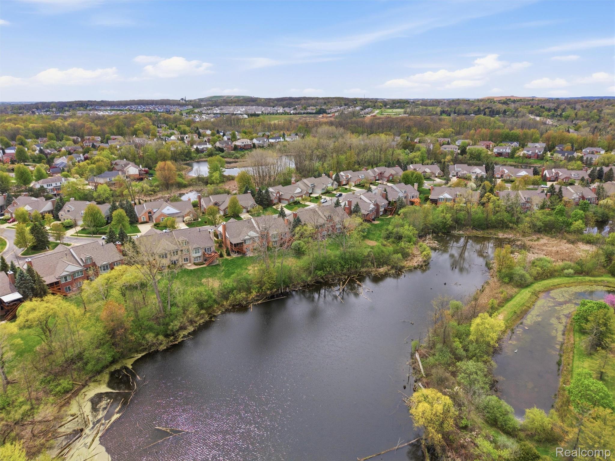 5211 Belmonte Drive Rochester, MI 48306 - Photo 3 of 40 Expansive residential community featuring a prominent pond and lush surrounding greenery