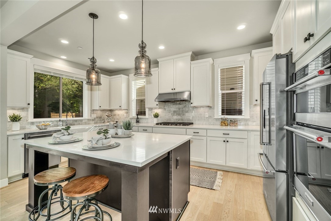 3318 238th Place Southeast Bothell, WA 98021 - Photo 12 of 36 a kitchen with stainless steel appliances kitchen island granite countertop a sink and cabinets